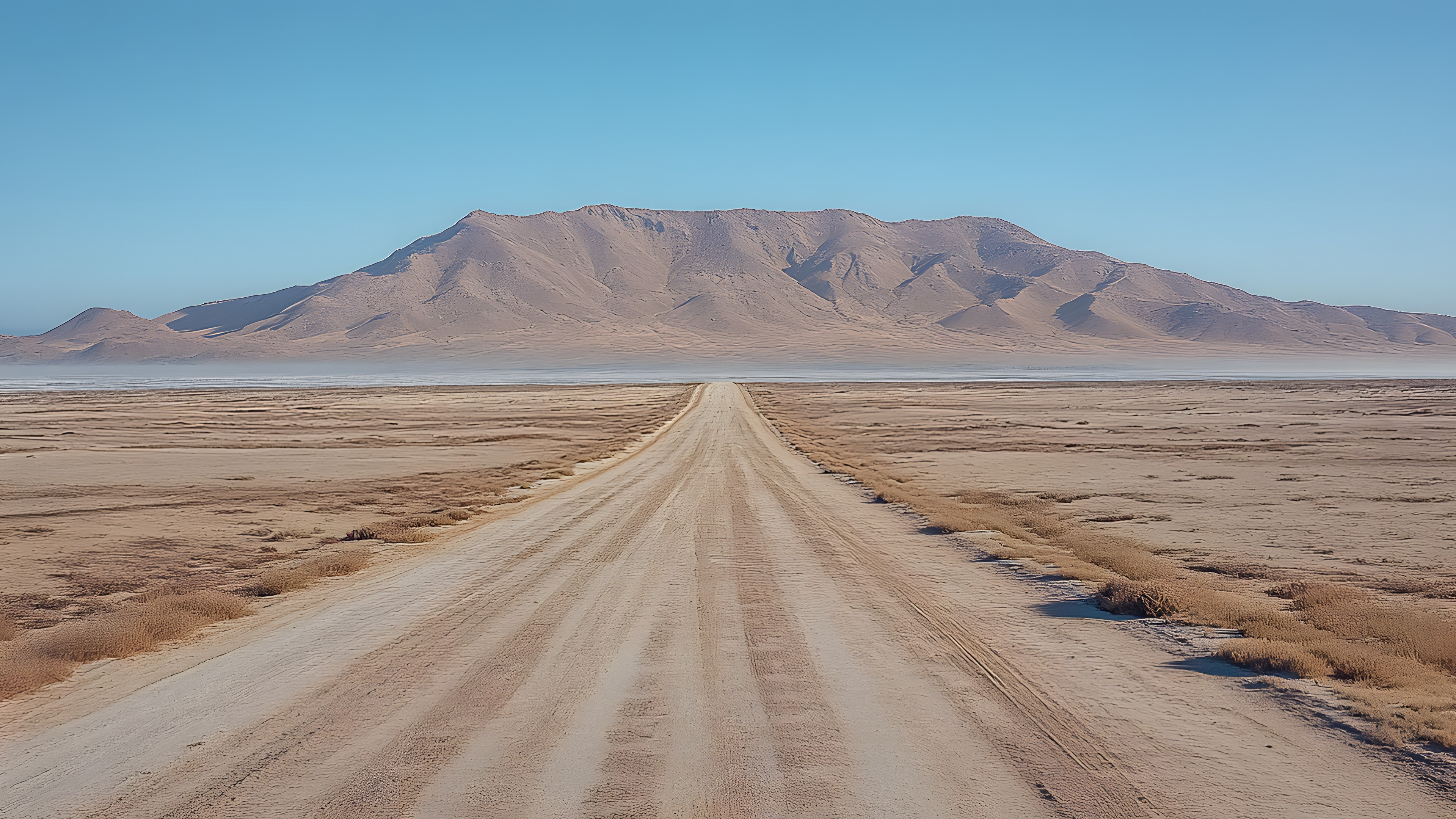 Sky, Mountainous landforms, Mountain, Ecoregion, Horizon, Aeolian landform, Desert, Landscape, Sand, Hill, Brown, Plain, Terrain, Geological formation, Plateau, Geology, Mountain range, Dirt road, Badlands, Soil