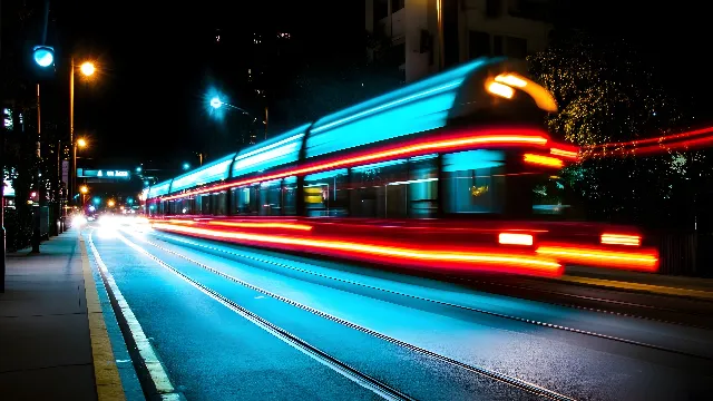 Mode of transport, Red, Night, Electricity, Lighting, Metropolitan area, Automotive lighting, Public transport, Midnight, Public utility, Metropolis, Neon, Electrical Supply, Train, Electronic signage, Bus, Rolling stock, Headlamp