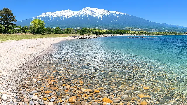 Water, Sky, Mountain, Water resources, Daytime, Green, Natural landscape, Azure, Natural environment, Lake, Tree, Coastal and oceanic landforms, Watercourse, Bank, Landscape, Beach, Horizon, Morning, Mountainous landforms, Mountain range