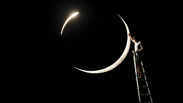 Sky, Crescent, Moon, Midnight, Event, Darkness, Astronomical object, Entertainment, Performing arts, Eclipse, Electricity, Night, Symbol, Font, Pole, Tree, Circle