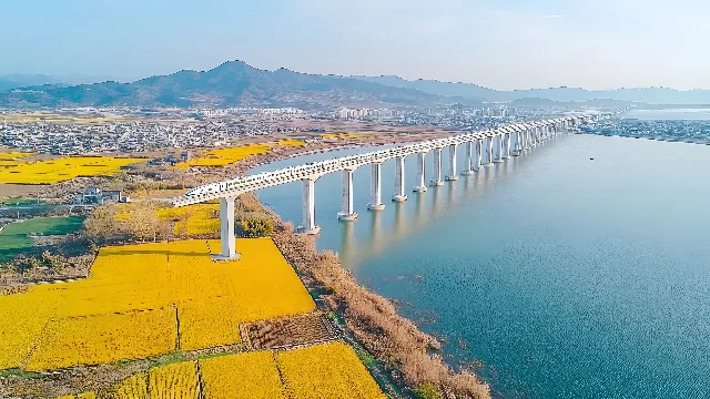 Water, Sky, Water resources, Azure, Mountain, Coastal and oceanic landforms, Lake, Bridge, Horizon, Landscape, Waterway, Headland, Road, City, Cloud, Suspension bridge, Concrete bridge, Reservoir, Cable-stayed bridge, Coast